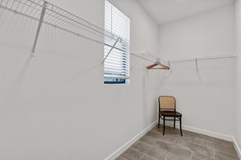 A room with a closet and a chair and a window